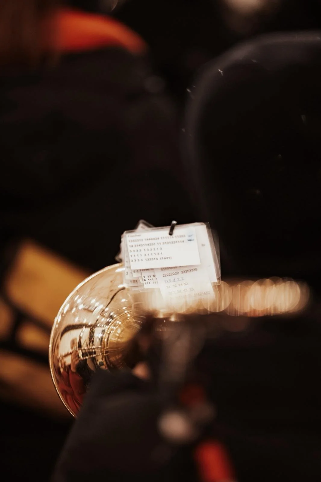 Eine Trompete, die auf einem dunklen Hintergrund liegt, mit einem Blick durch das Schallstück auf das Etikett.