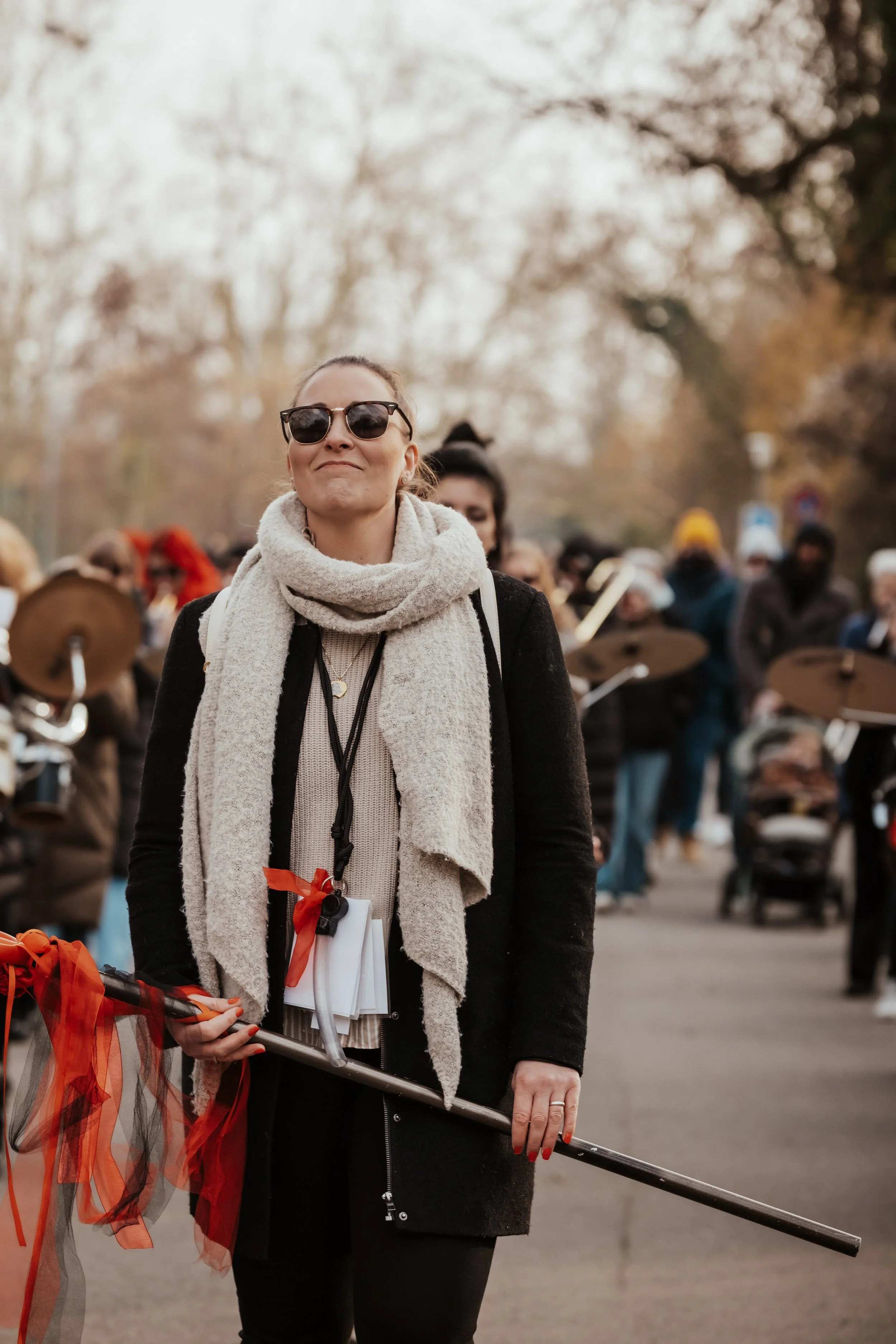 Frau mit Sonnenbrille, Schleier und Zauberstab bei einer Parade oder Fest