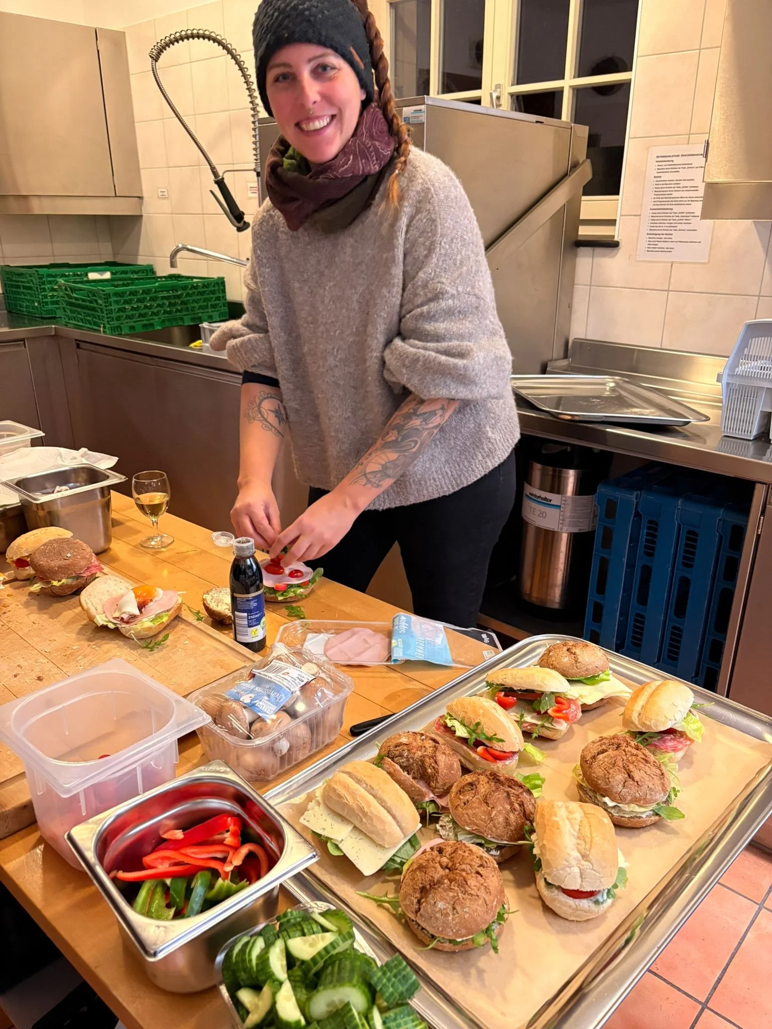 Eine Frau bereitet mehrere Sandwiches und Burger in einer Küche vor.