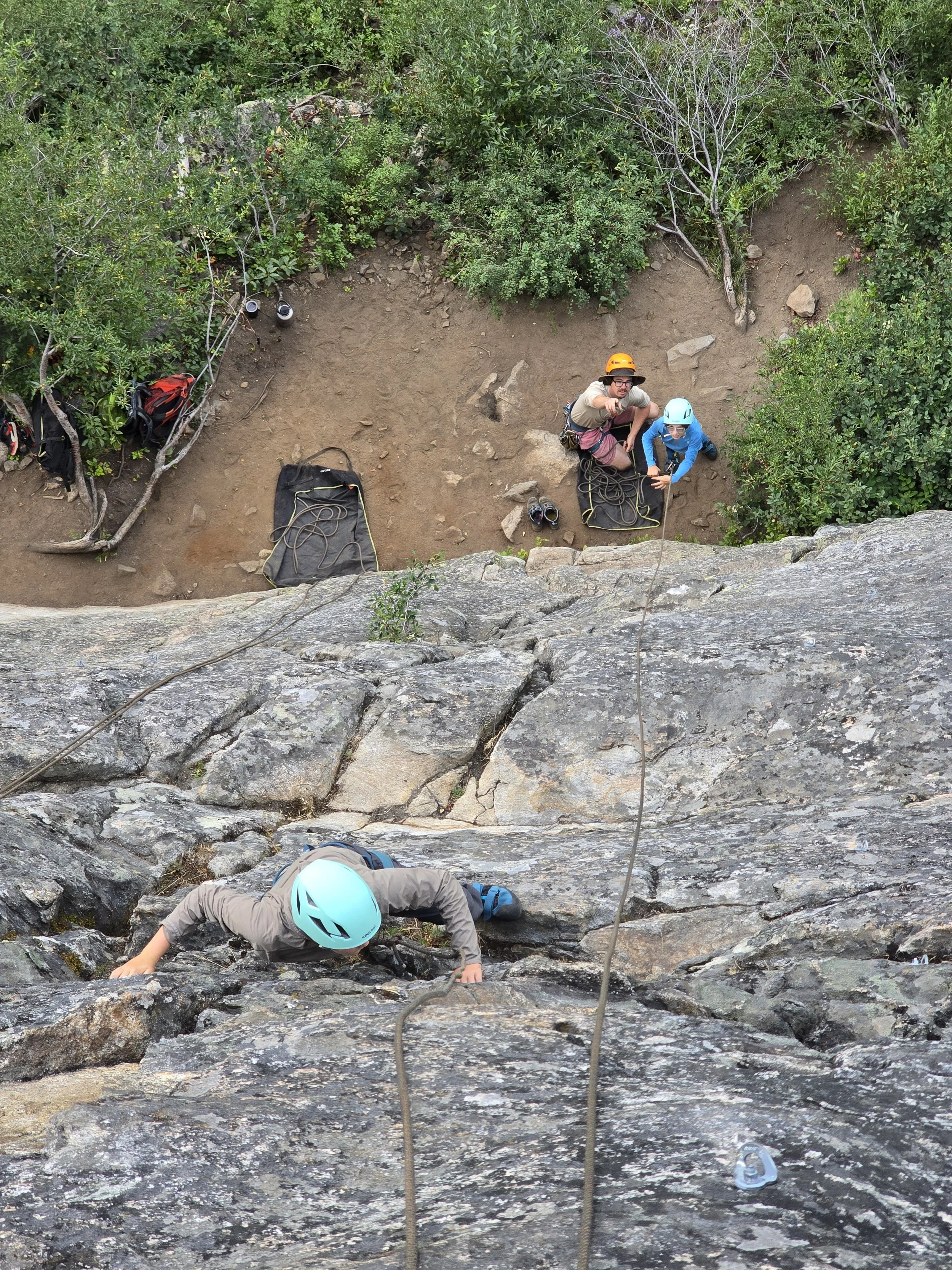 Collin backs up a belayer as he practices while a friend climbs.