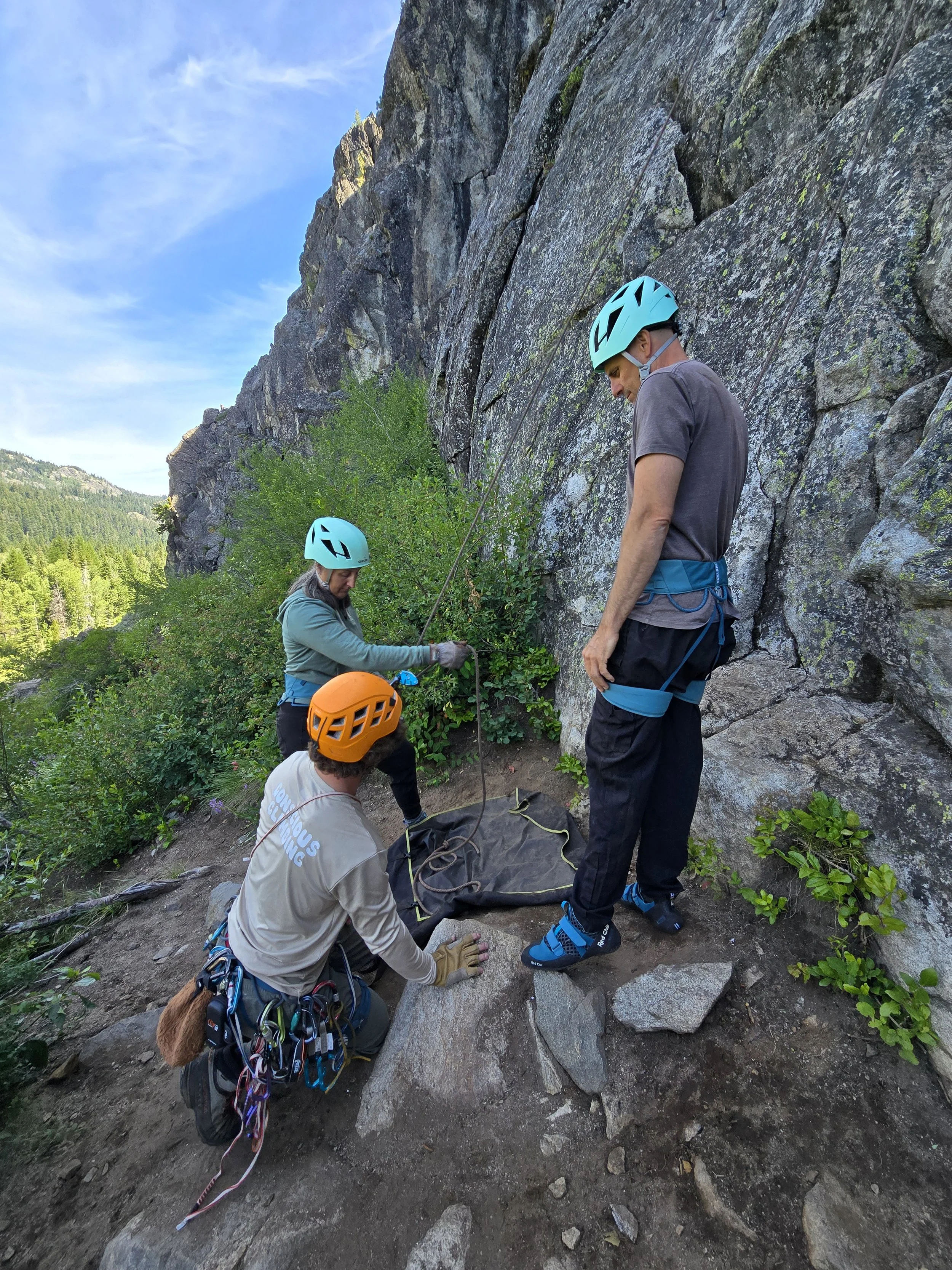 Our lead guide Collin is walking a couple through their belayer-climber safety checks before they begin climbing.
