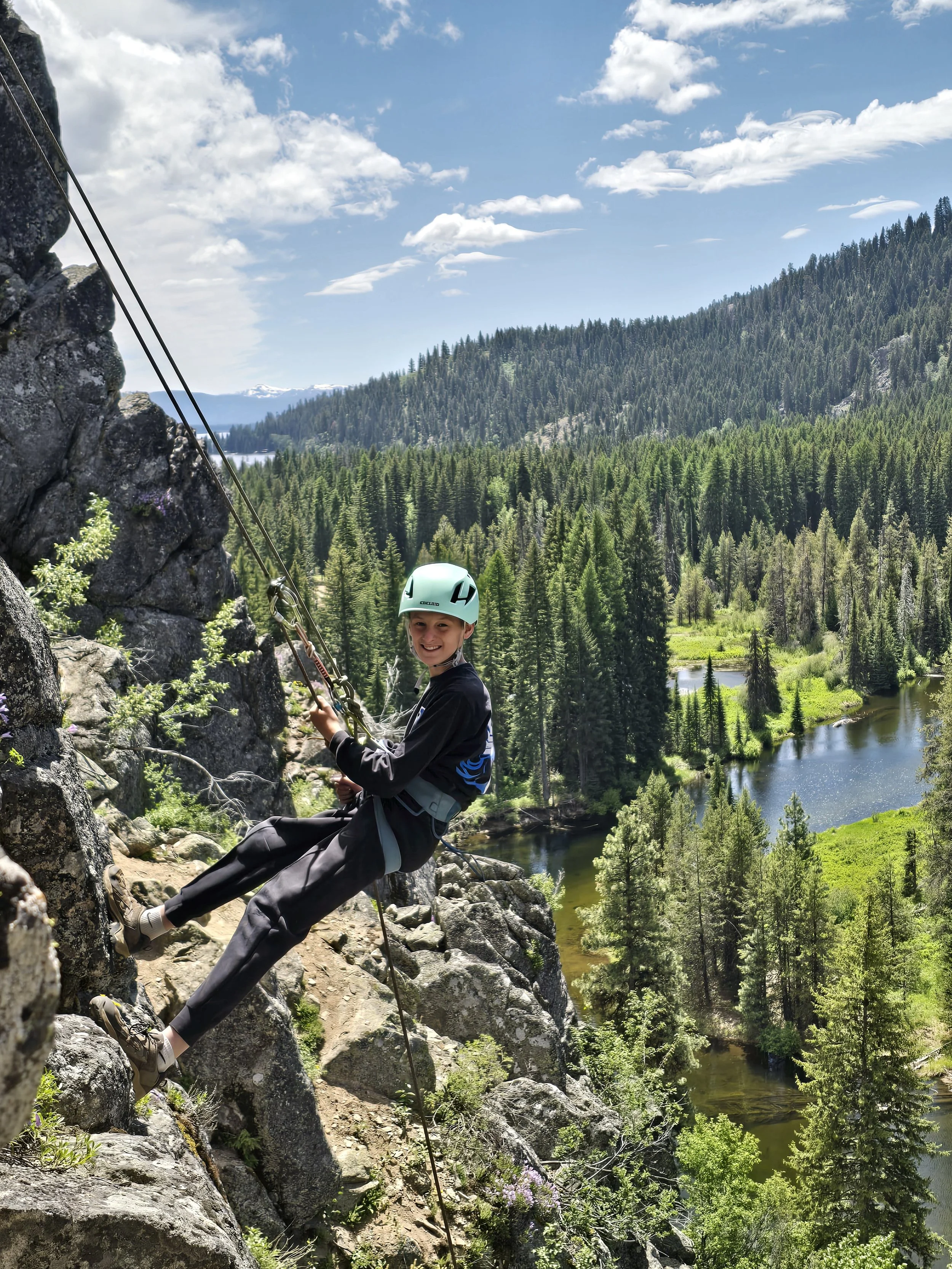 A climber smiles as he rappels down the cliffs.