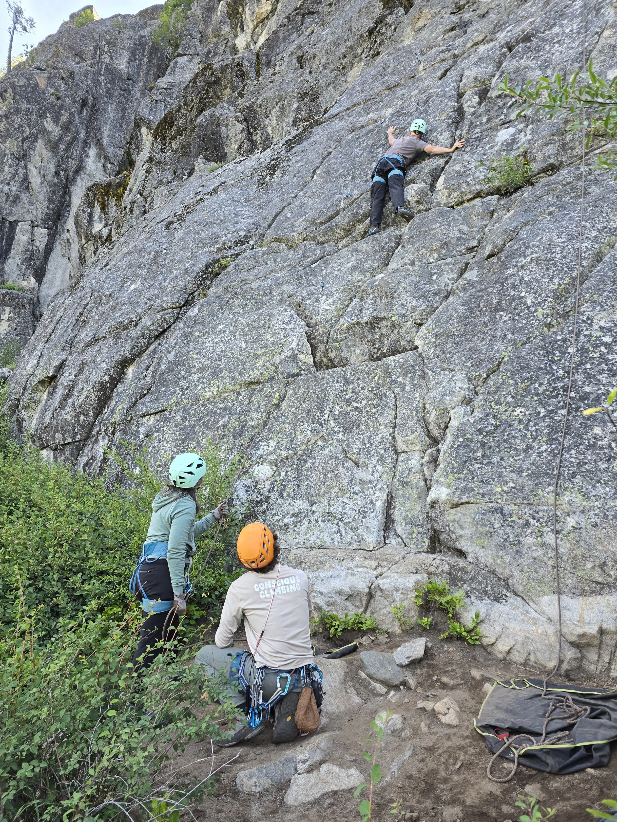 Our lead guide Collin is backing up a woman while she learns and practices belaying.