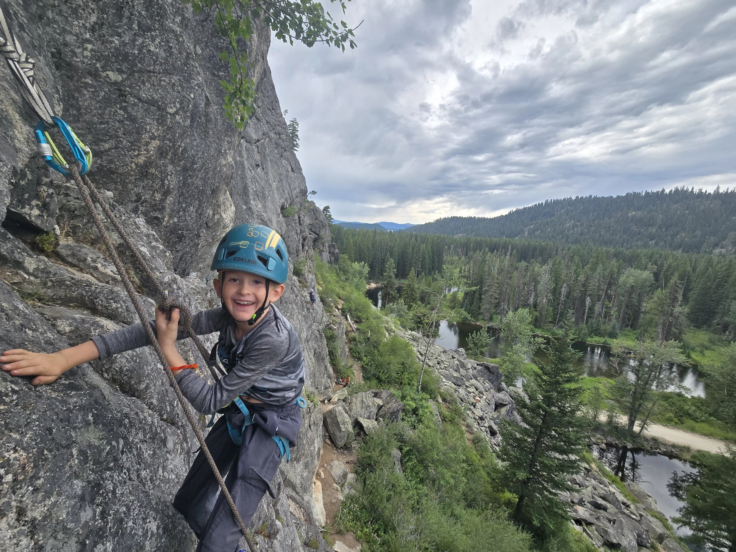 Our young participant smiling with joy after climbing to the top of a route.