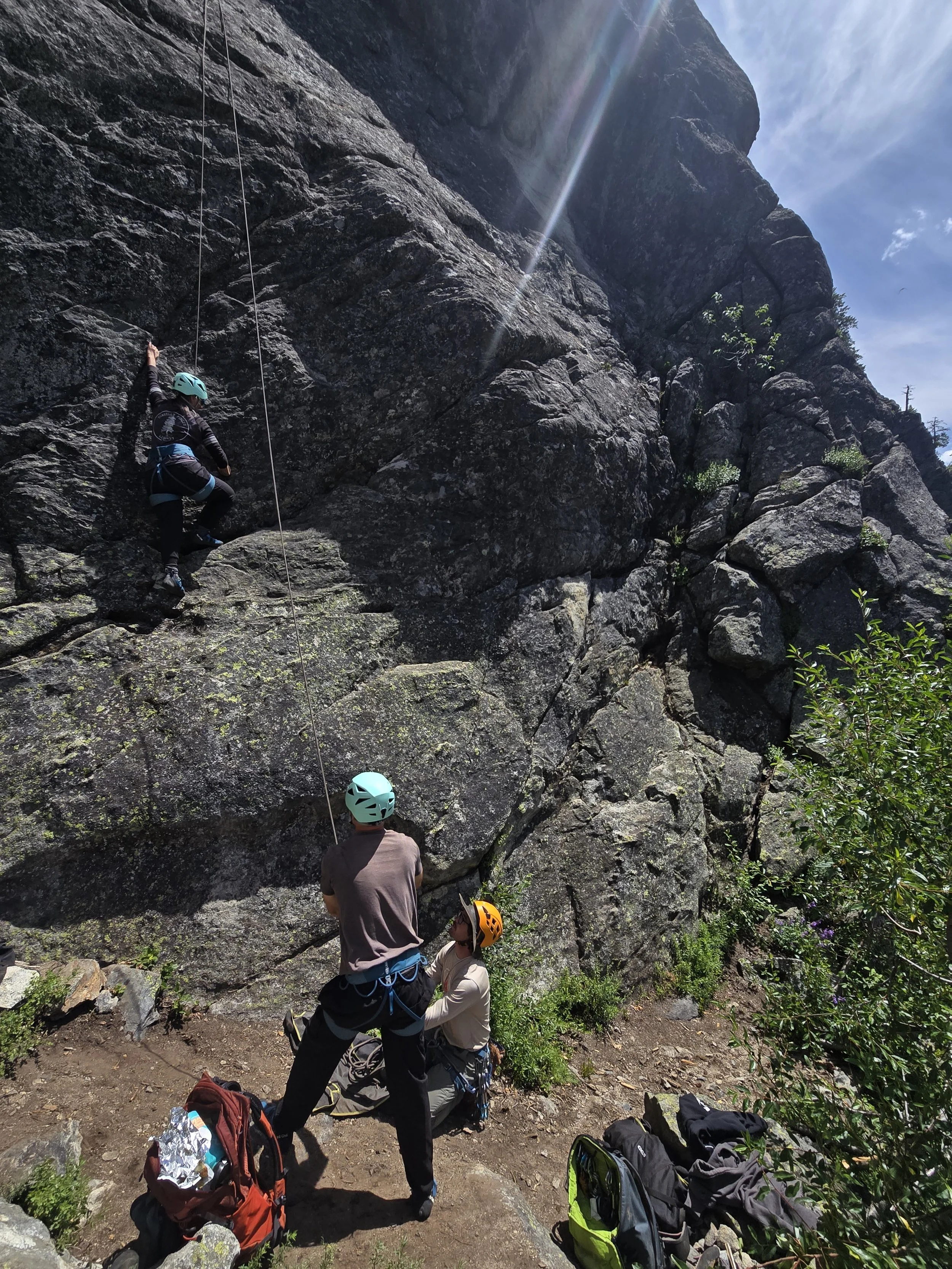 Collin is backing up a belayer as they learn.