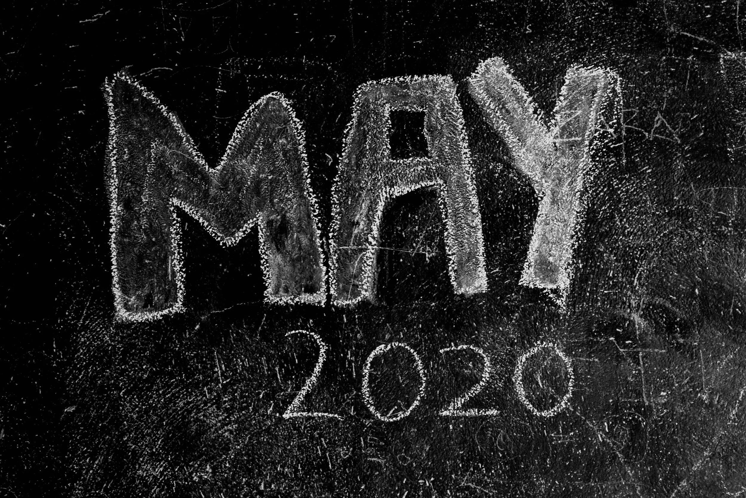 The word 'MAY' and the year '2020' written in chalk on a black chalkboard.