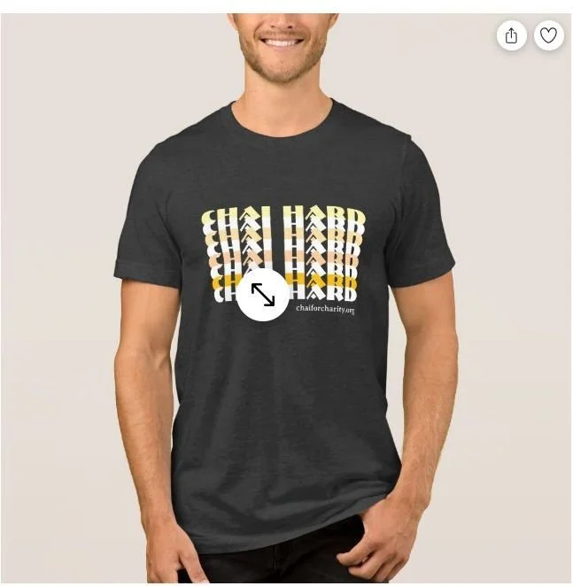 A man wearing a black T-shirt with repeating yellow and white text that reads 'CHAIR HARB' and a URL 'chairforcharity.com'.