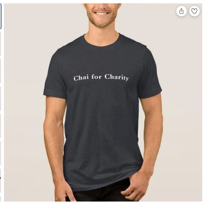 A man wearing a dark gray T-shirt that says "Chai for Charity" in white letters.