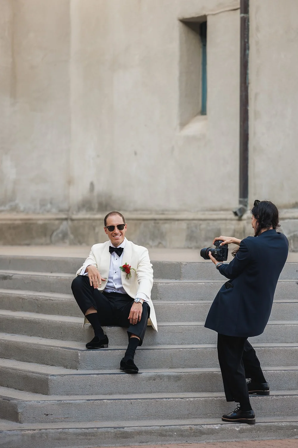 Groom posing on the steps while being photographed