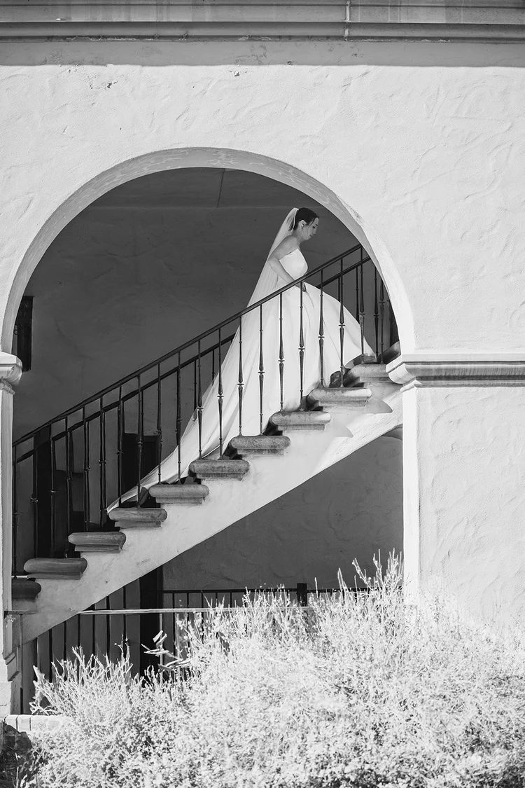 Bride descending a white staircase, black and white