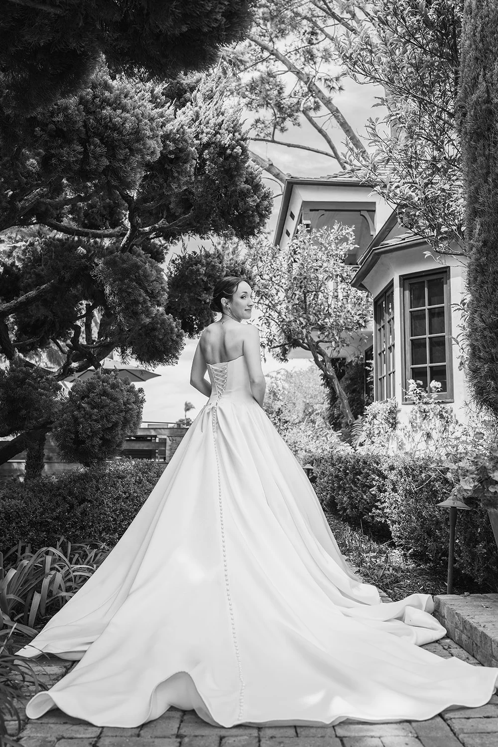 Bride's gown and train in a garden, black and white