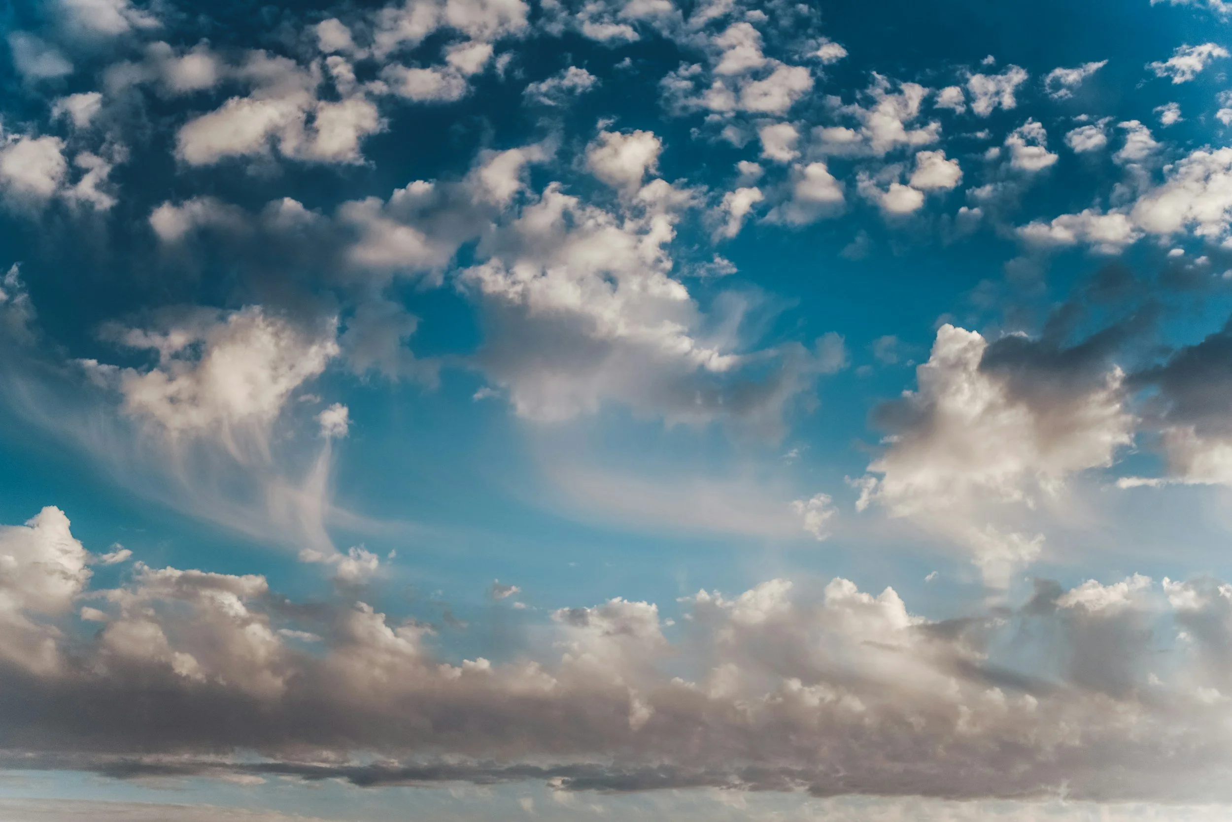 A blue sky dotted with many types of clouds.