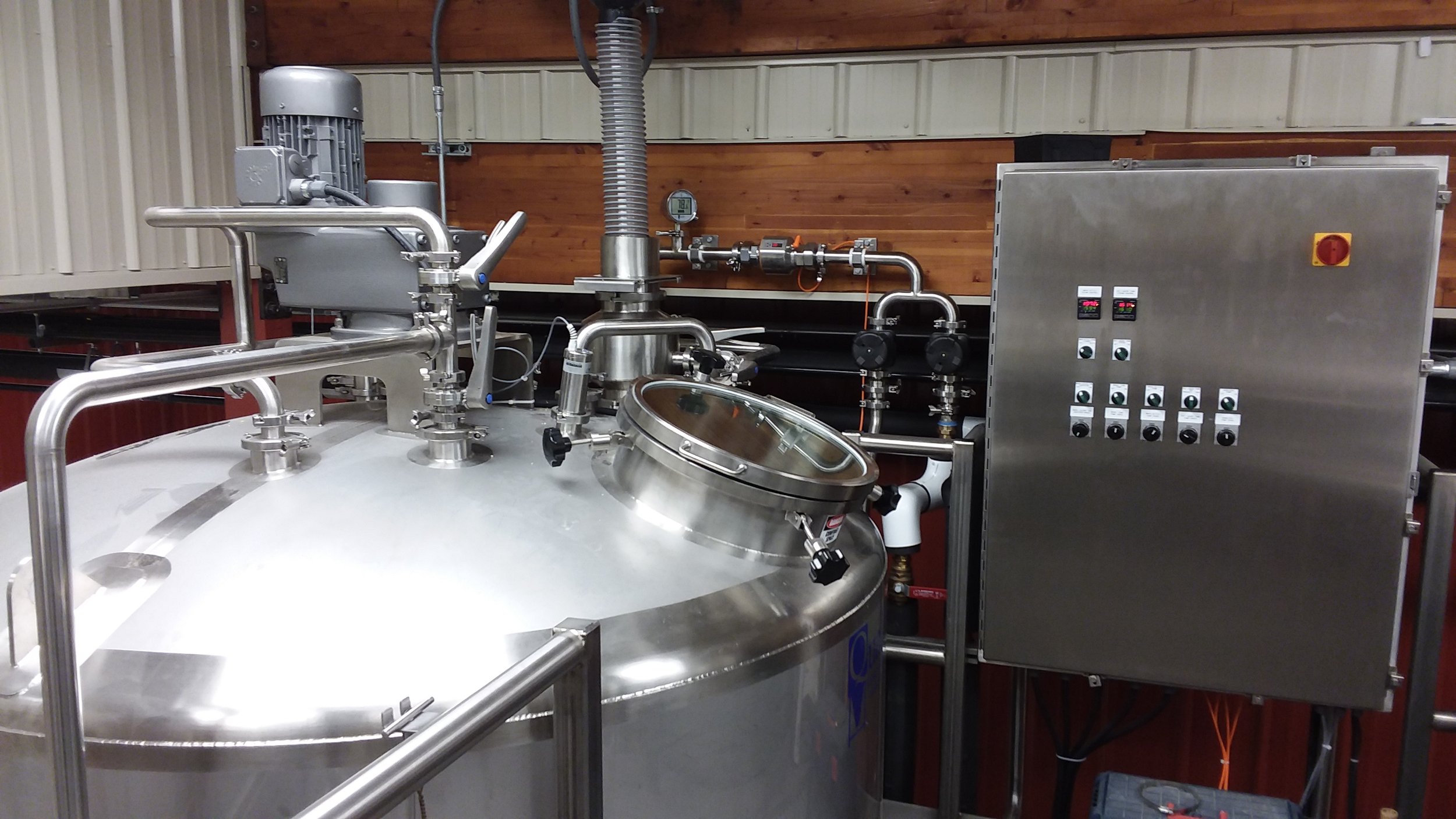 Catwalk of brewery showing stainless steel  malt tun and electrical panel.