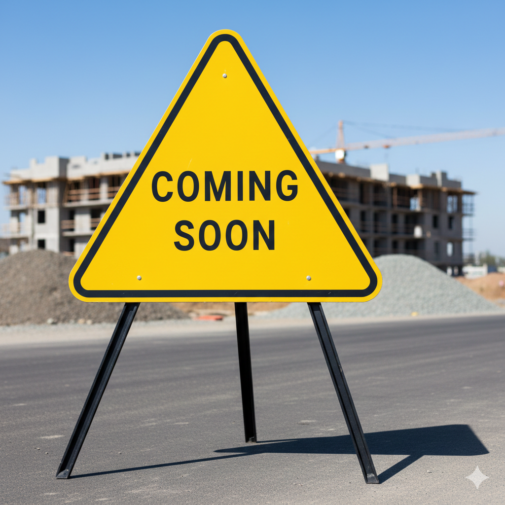 Yellow triangle road sign with black border and the words "Coming Soon" in black, set against an under-construction building and clear blue sky.