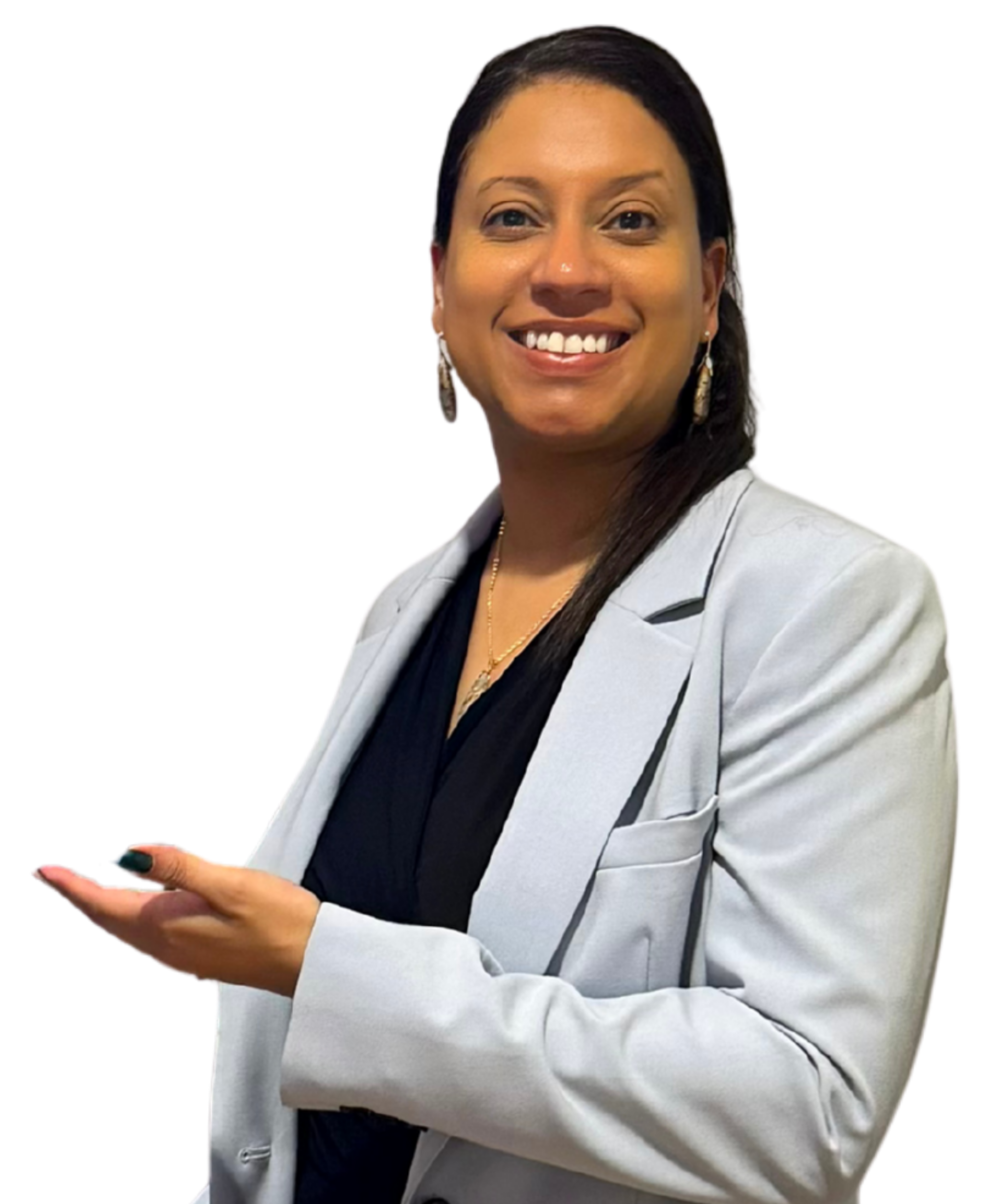 A woman with long dark hair, smiling, wearing a light gray blazer over a black top, accessorized with earrings and a necklace, gesturing with her right hand.
