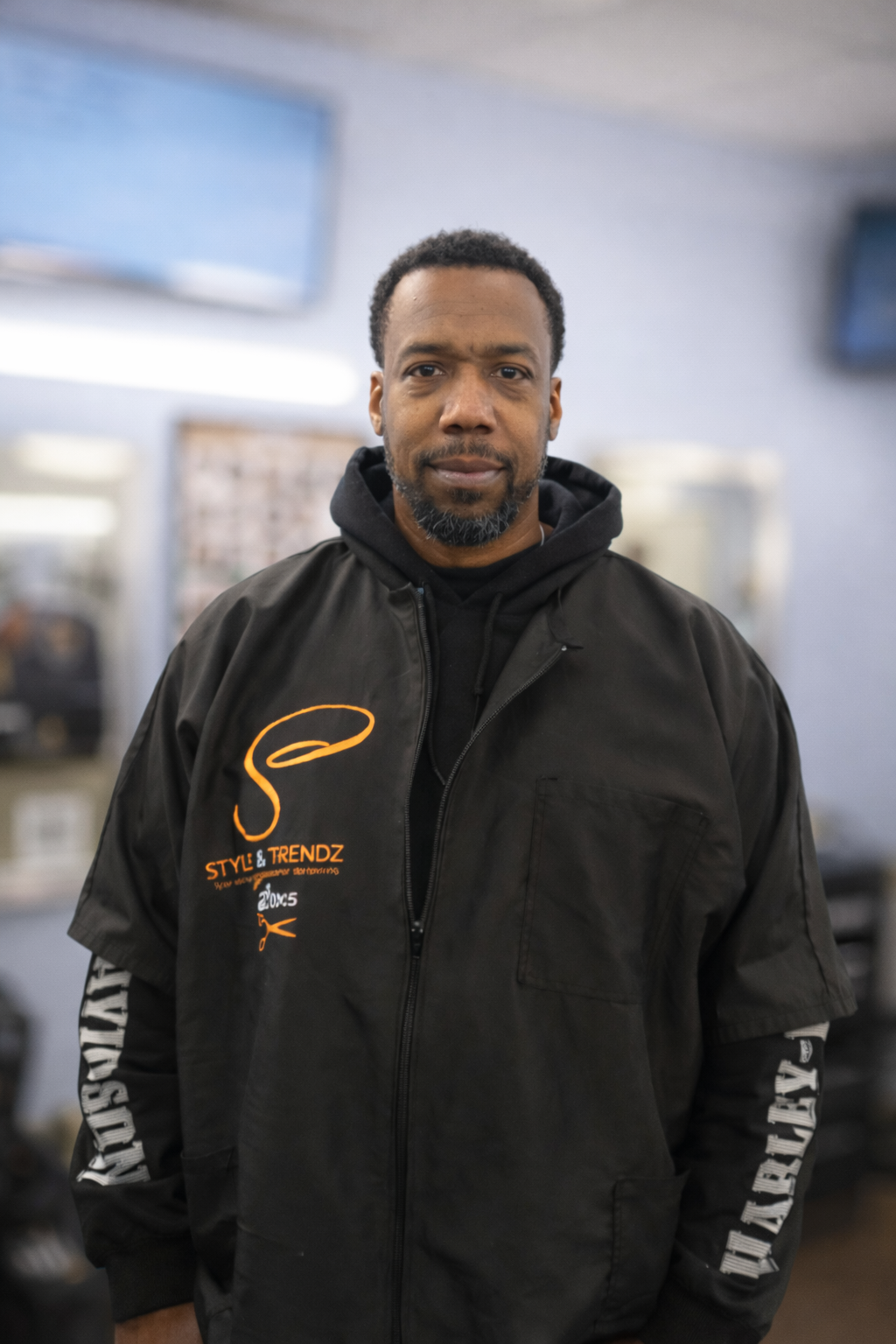 Logo for Stylz & Trendz, a professional barbering business established in 2005, featuring a red hair strand and scissors design.