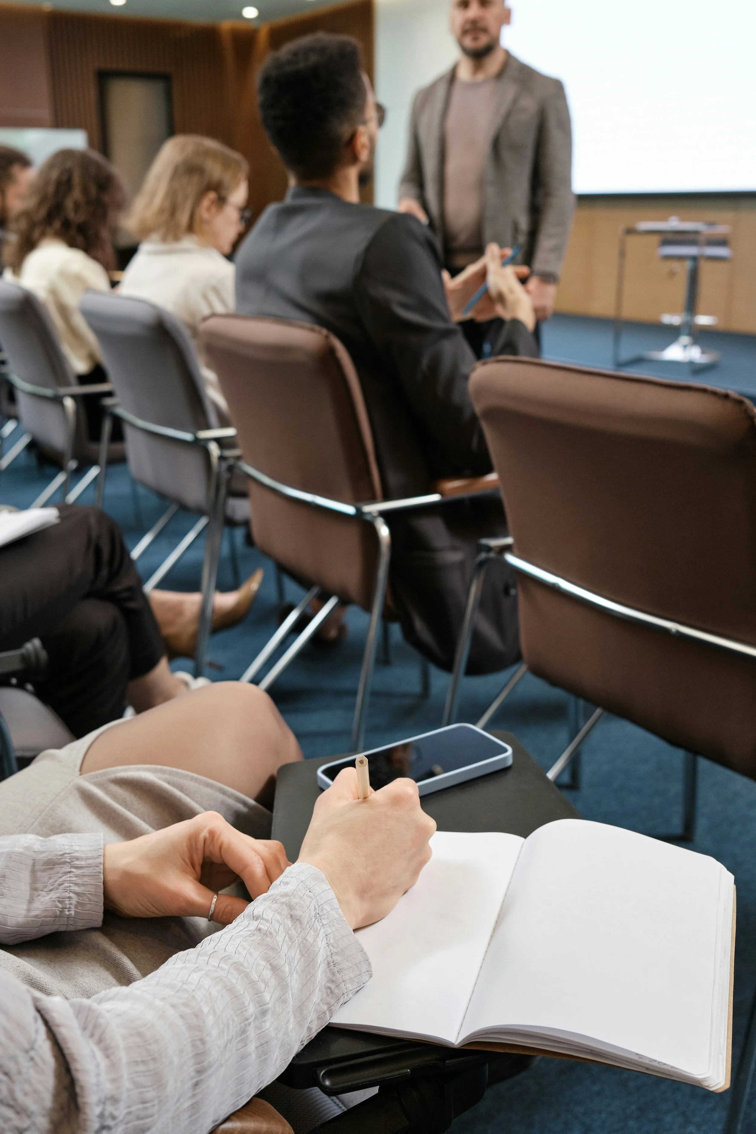 Conference presentation setting representing conversation-focused leadership and professional dialogue