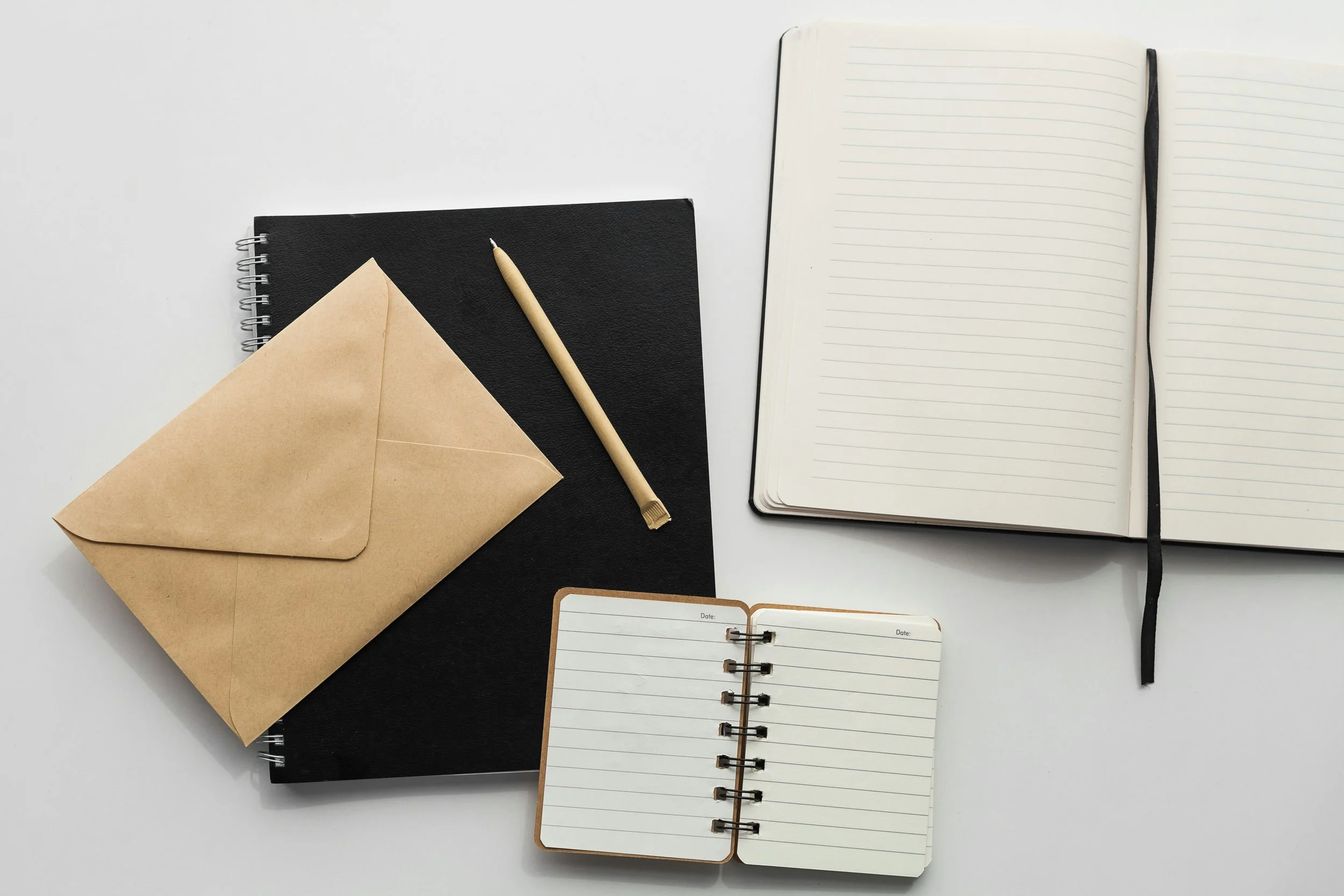 Notebook, pen, and envelope representing reflective writing and thoughtful communication