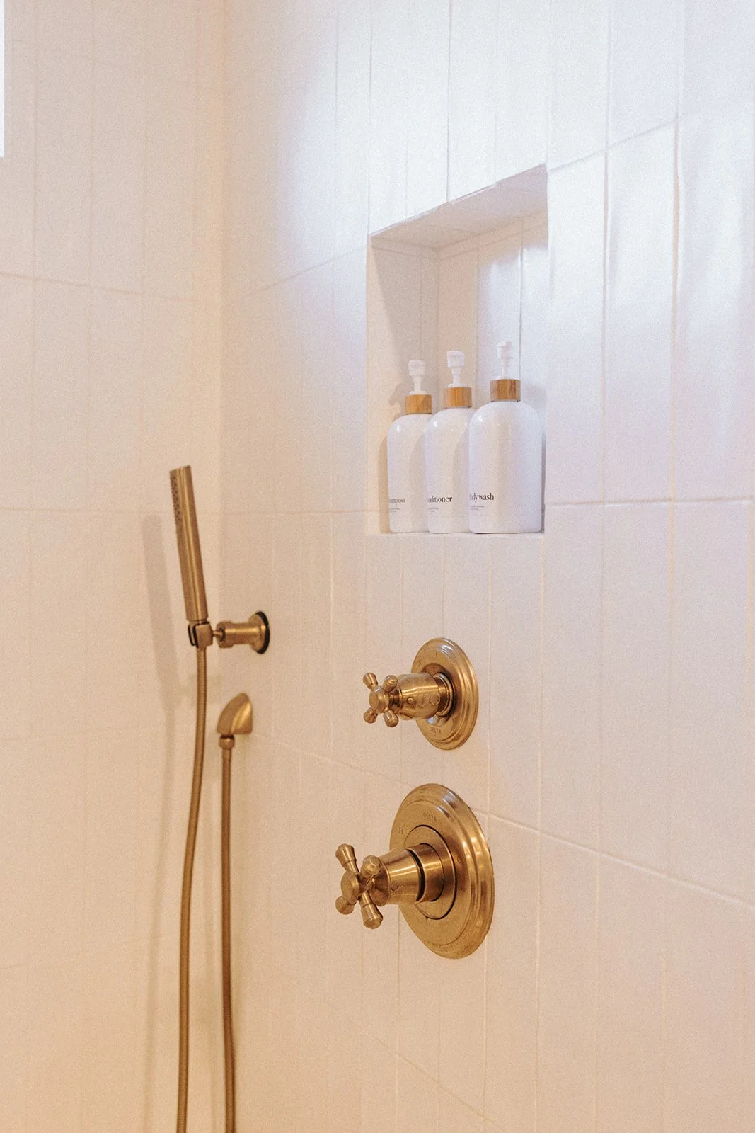 Primary bathroom featuring dual shower heads, custom shower niches, a handmade double vanity with tower, and even a custom vent cover.