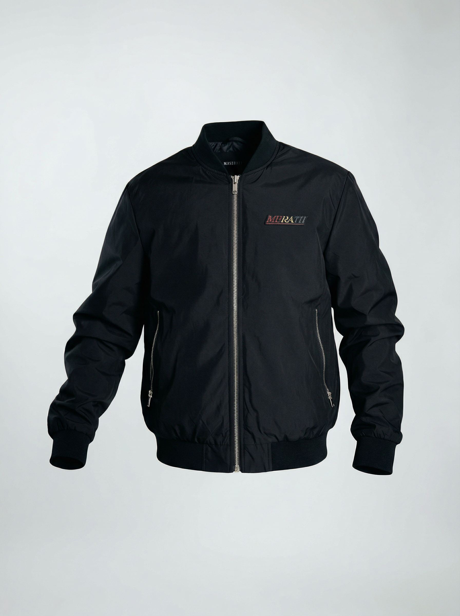 Black bomber jacket with zippered pockets, embroidered patch on chest, and ribbed cuffs and waistband.