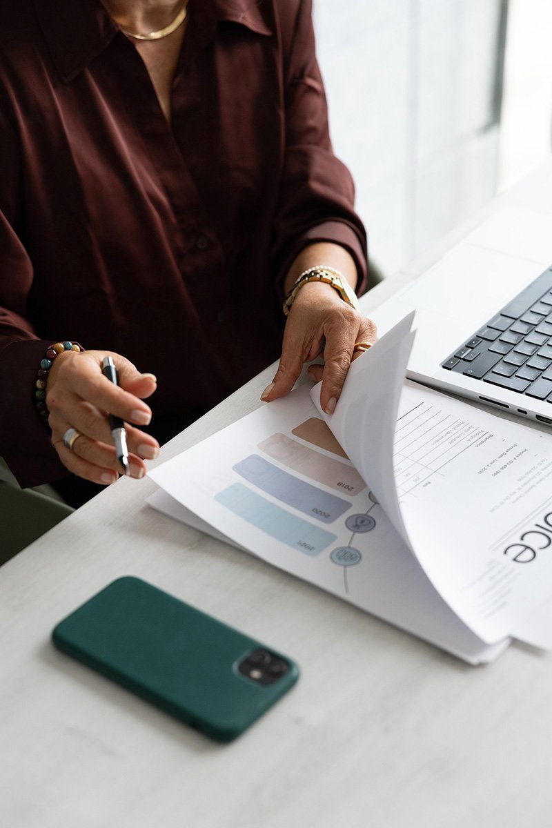 woman business owner sitting at desk looking at reports and social media strategy documents