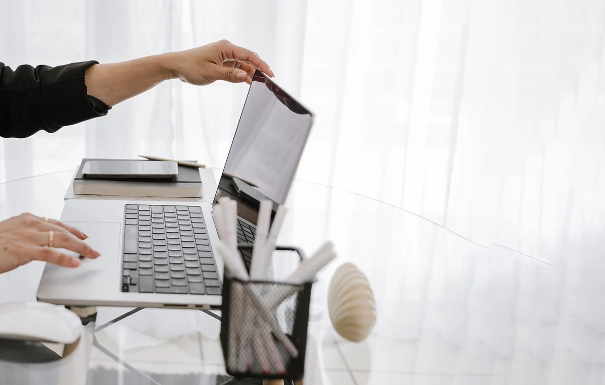 close shot of woman business owner's hands on laptop at desk