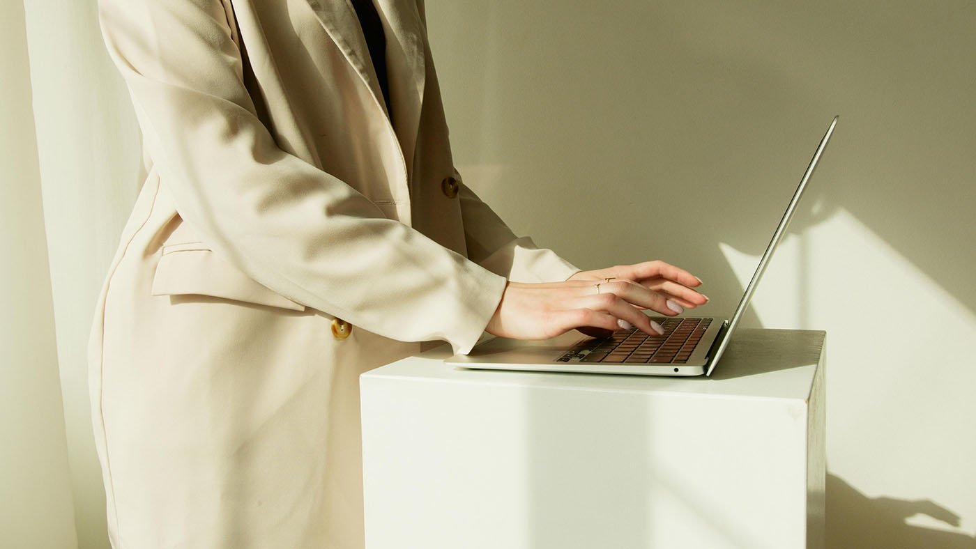 woman business owner typing on computer, working on social media discovery strategy