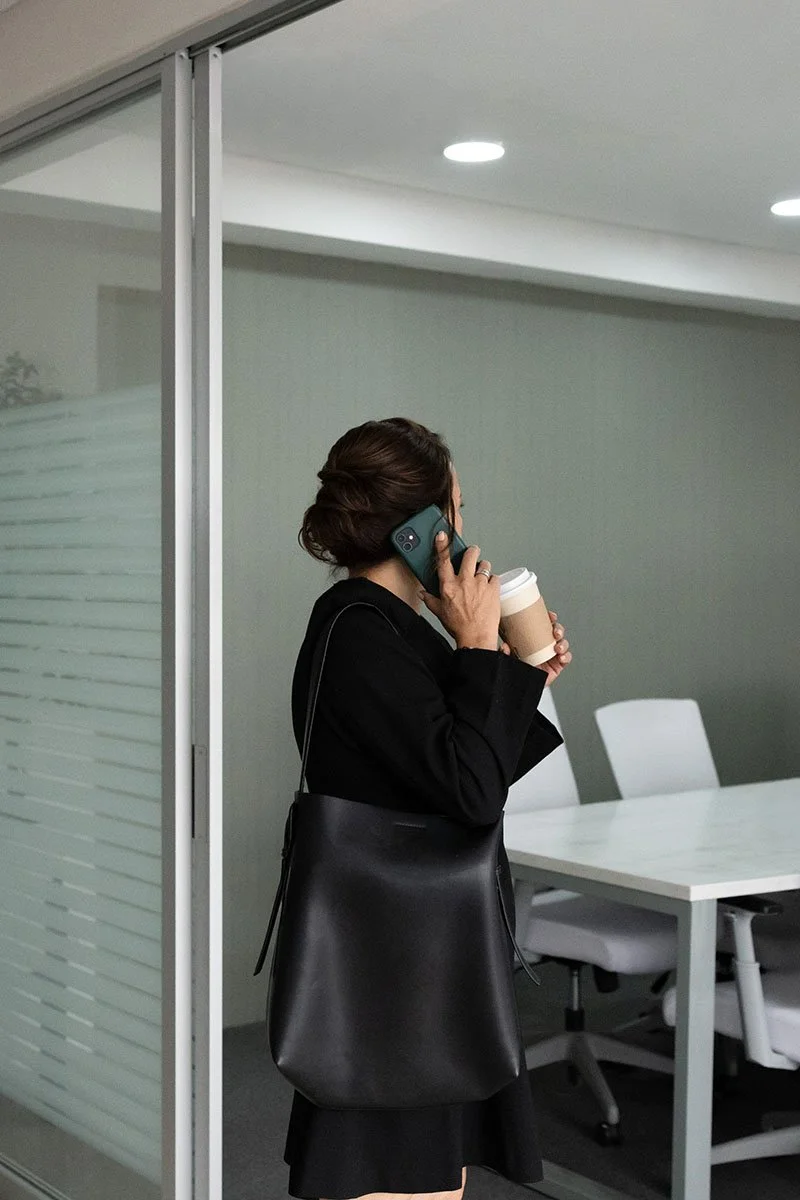 woman business owner on cell phone standing in conference room