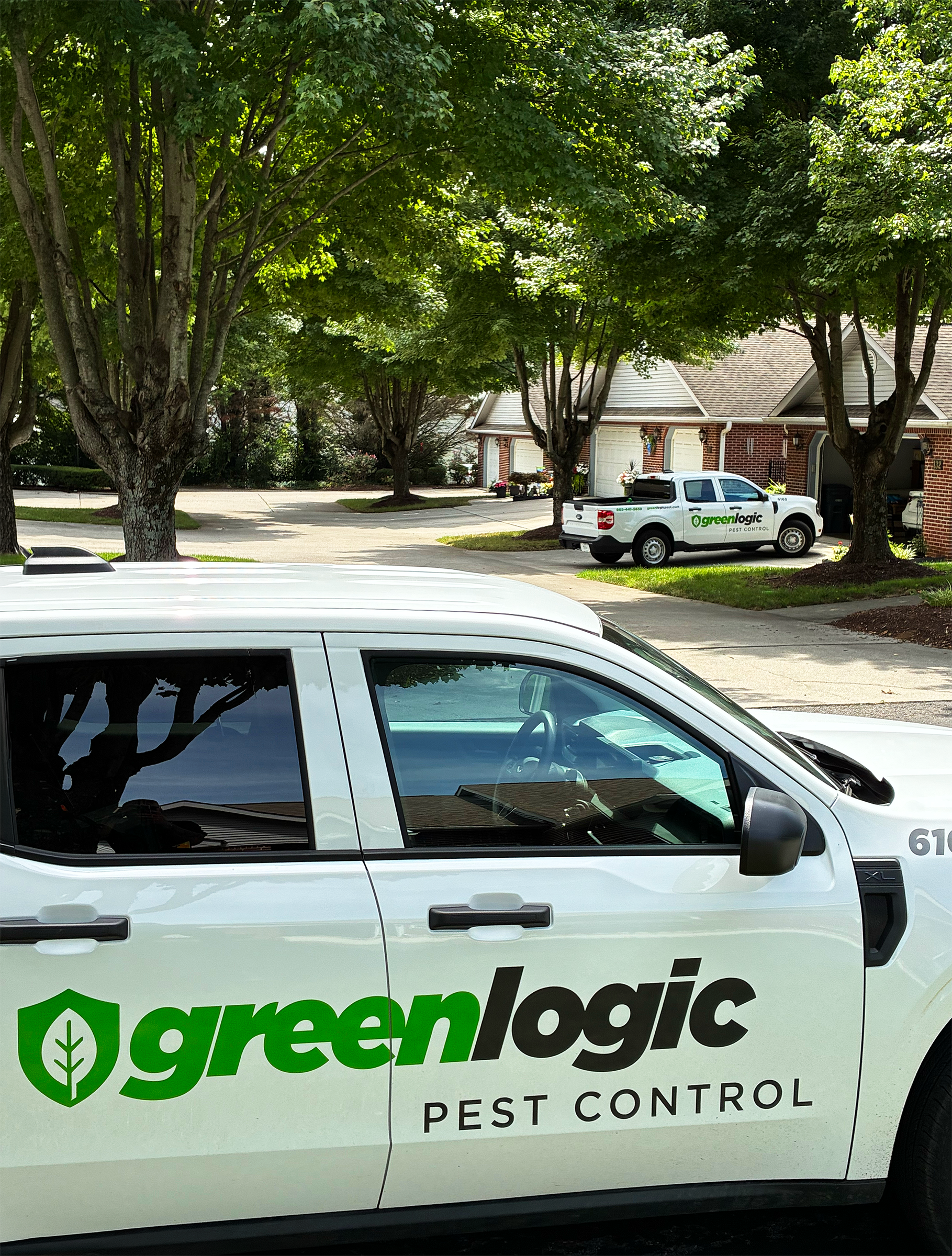 Greenlogic Pest Control Service Trucks in a neighborhood in East Tennessee