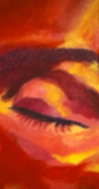 Close-up of a painted eye with vibrant warm colors like red, orange, and yellow.