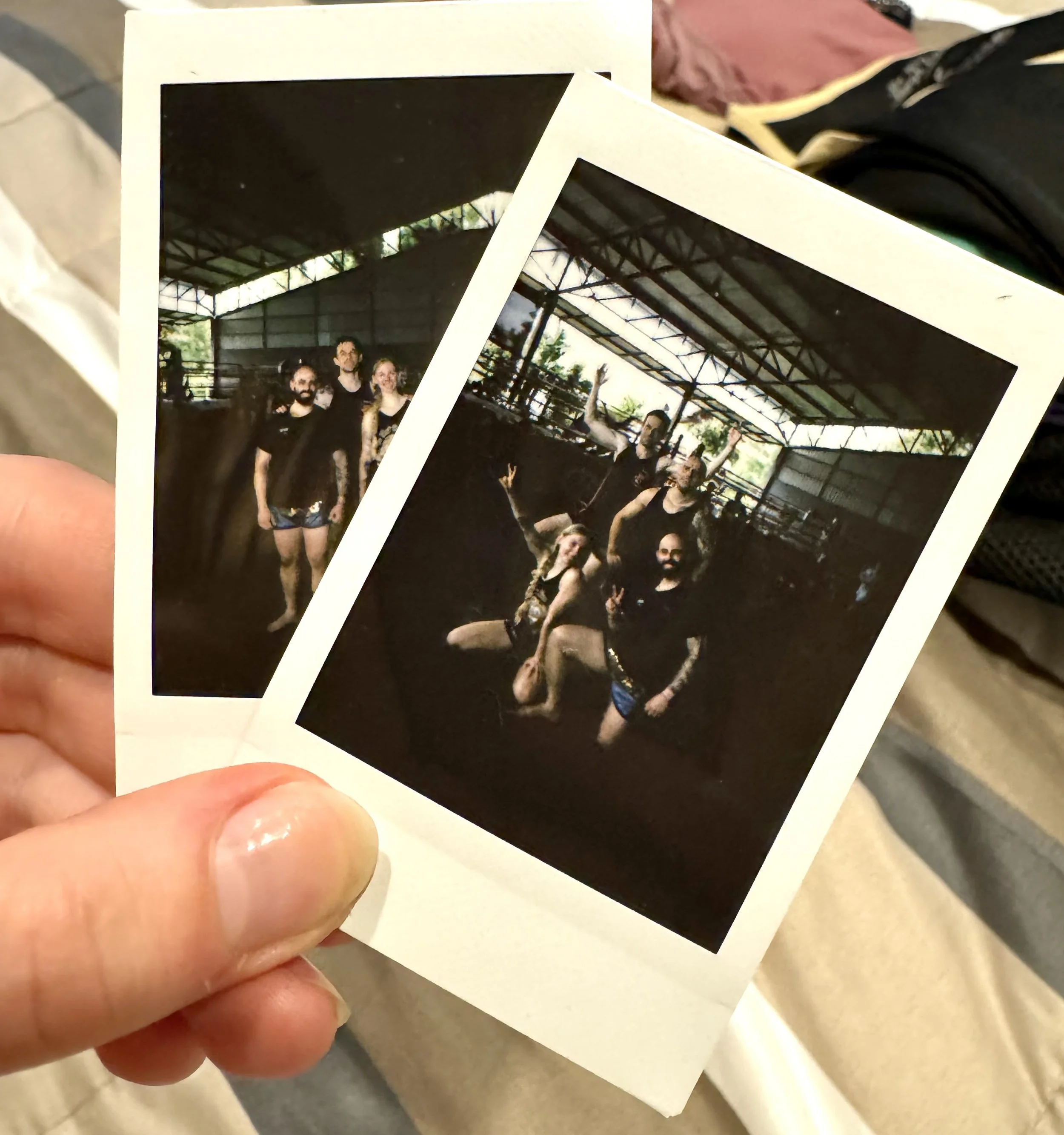 Two printed photos of a group of people posing inside a big Muay Thai gym located in Thailand.