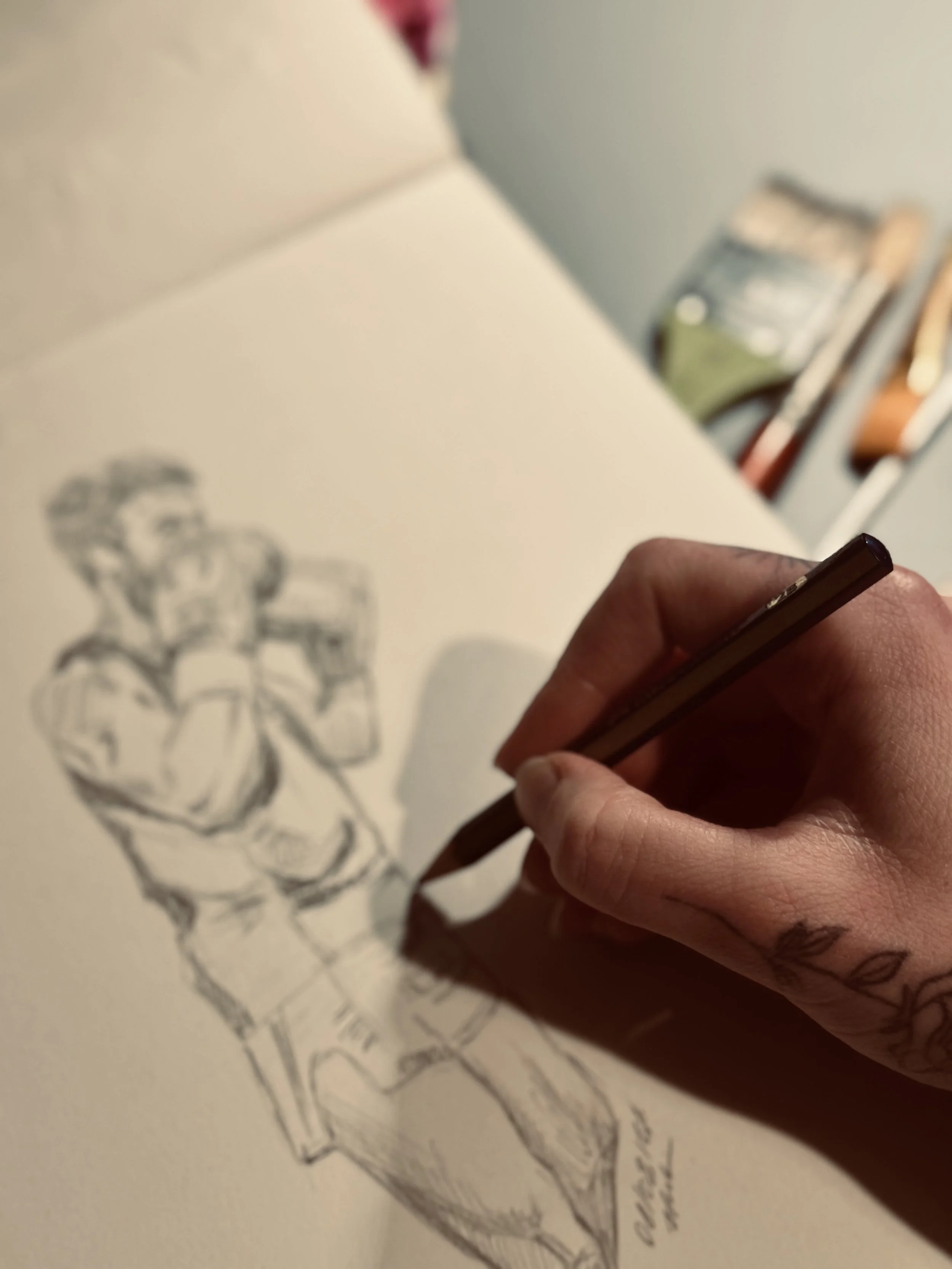 A person drawing a sketch of a boxer depicted in a minimalist style on a piece of paper.