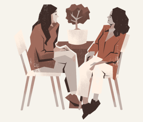 Two women having a conversation while seated, with a potted plant between them.