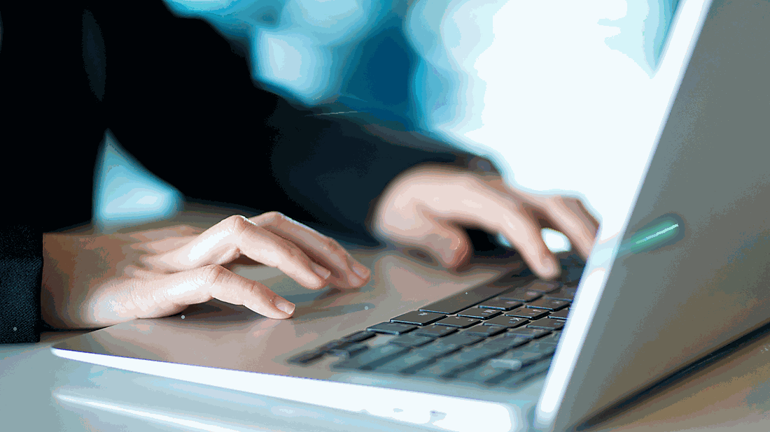 Person typing on a laptop keyboard.