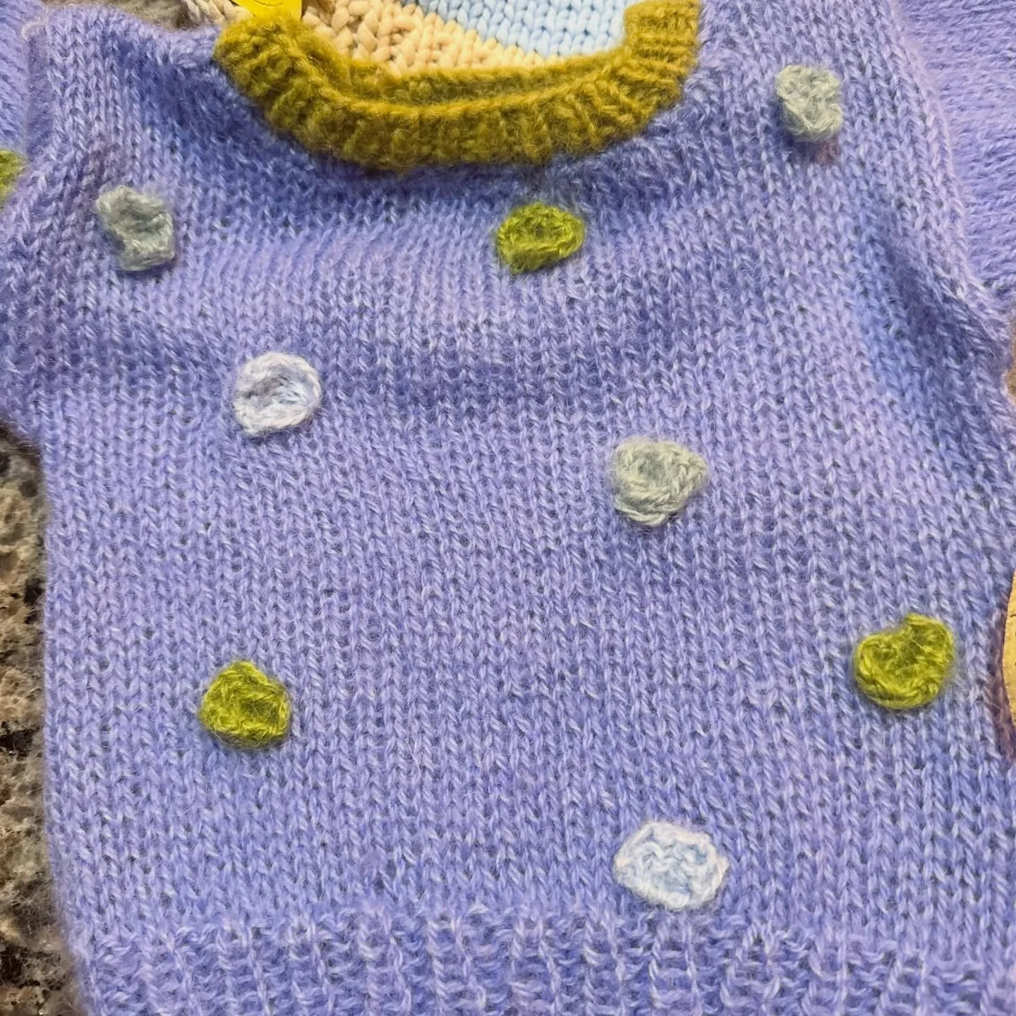 Handknit baby sweater 💜✨

Soft, cozy, and one-of-a-kind. This cornflower blue sweater is handknit with sweet textured dots in soft blue and moss green, and finished with a contrasting ribbed neckline. Perfect for keeping a little one warm while stil