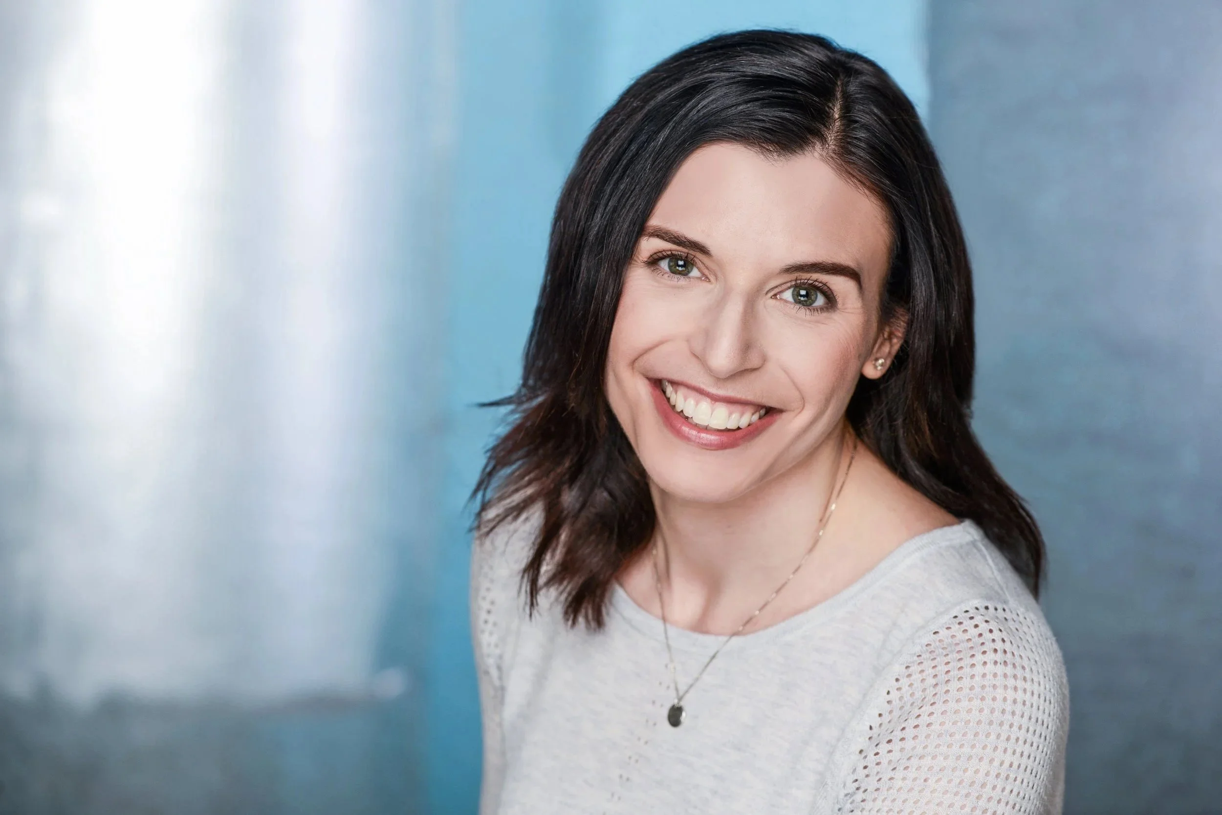 Professional headshot of Carrie Libling smiling against a soft blue background.