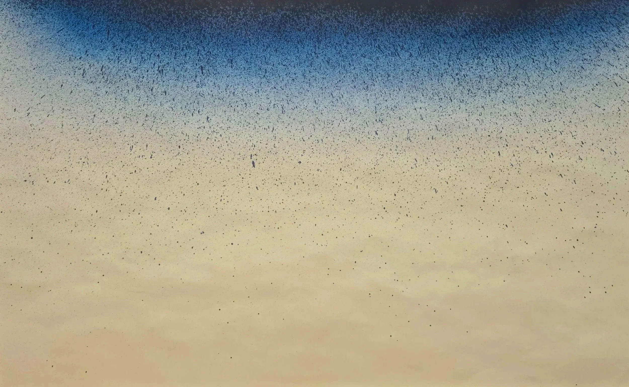 Close-up of a speckled surface with black dots on a gradient background transitioning from beige to blue.