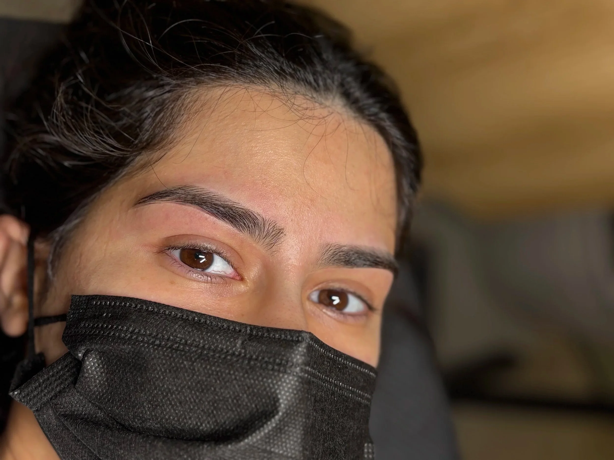 Close-up of a woman receiving brow tinting services. 