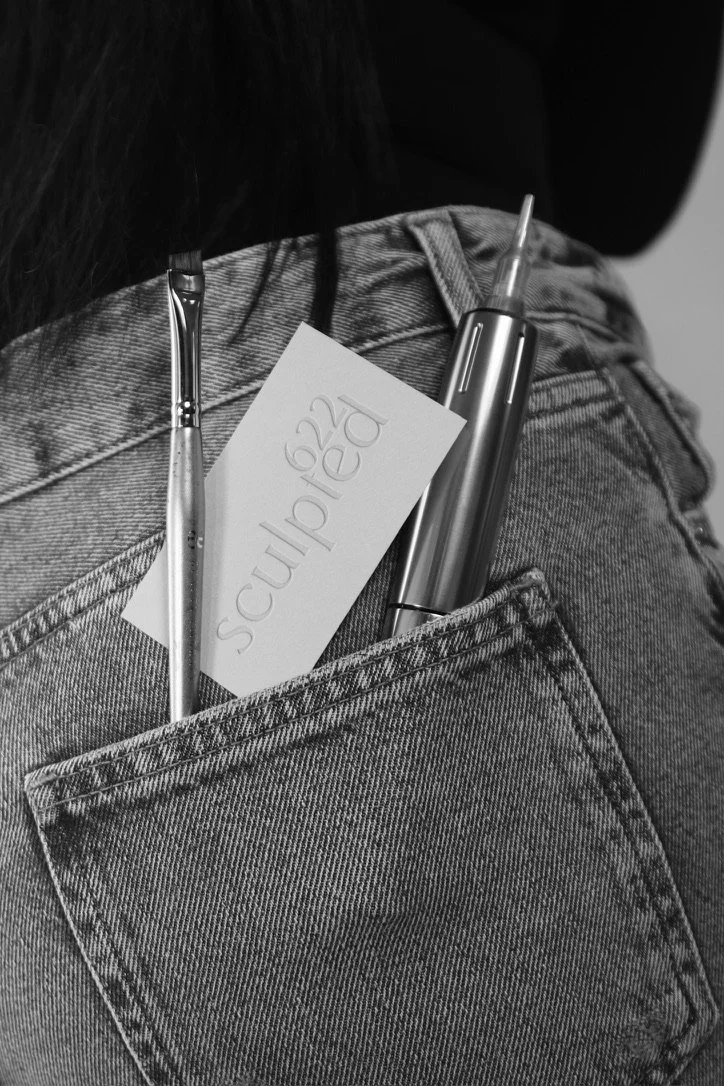 Back pocket of jeans with a pen, a stylus, and a note card inside