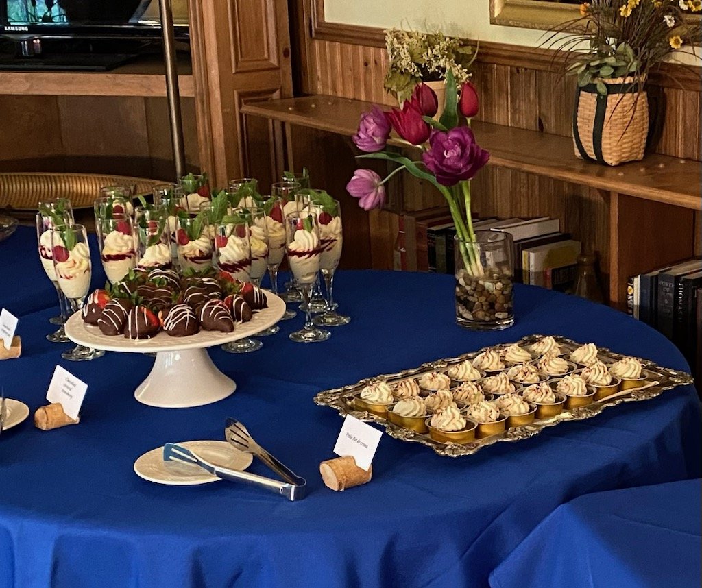 Crispy bite-sized appetizers topped with creamy sauce, garnished with lemon slices and flowers on a decorative platter.