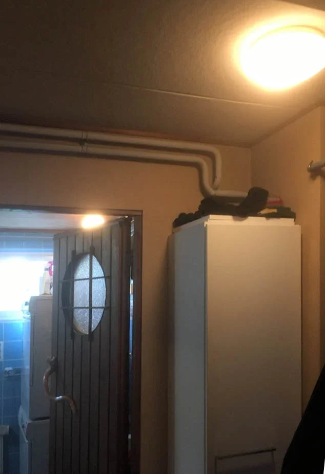 Kuva kodin sisätiloista, takana näkyy kylpyhuone ja edessä on valkoinen kaappi.