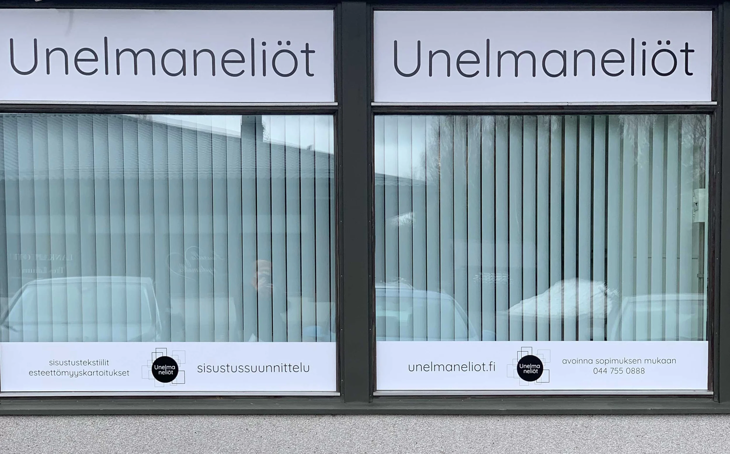 Ikkunan tekstejä, joissa lukee Unelmaneliöt molemmissa ikkunoissa ja ilmoitukset sisustussuunnittelusta, sisustustekstiileistä ja esteettömyyskartoituksesta. Lisää tekstiä ja logoja ikkunan alareunassa.