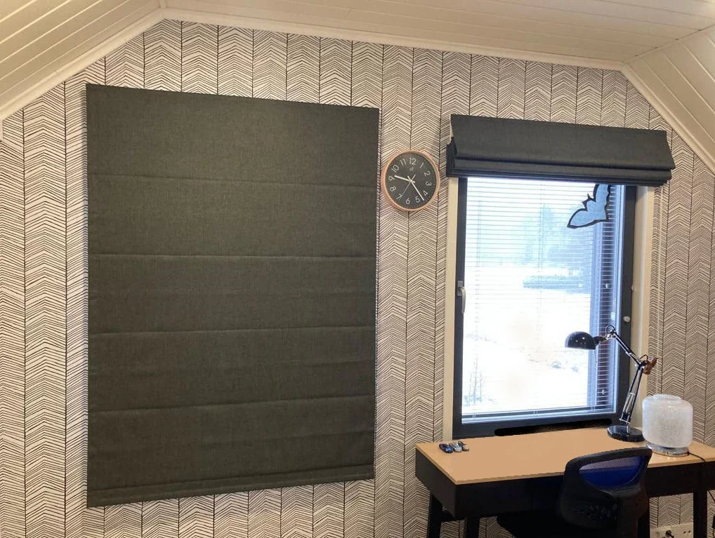 Harrastustila, jossa on akustinen seinä- ja ikkunarakenteet, pöytätietokone, työvalaisin ja kello seinällä.