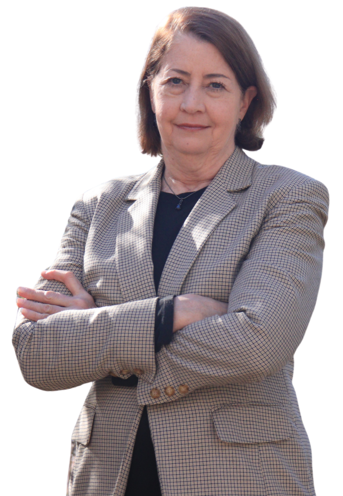 Julie Prince, with short brown hair, wearing a beige checkered blazer and a black shirt, standing with her arms crossed and smiling.