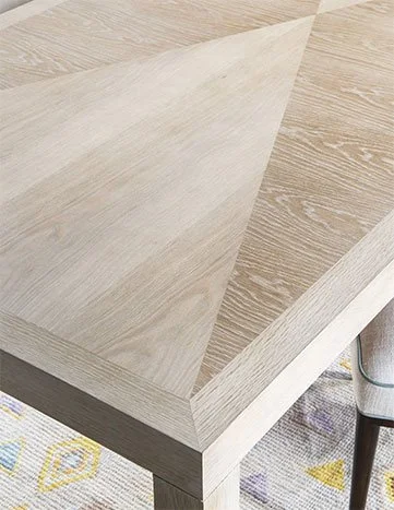 Close-up of a wooden table with a light-colored wood finish.