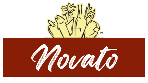 A logo with an illustration of fresh vegetables and herbs above a red banner that says "Novato" in white cursive font.