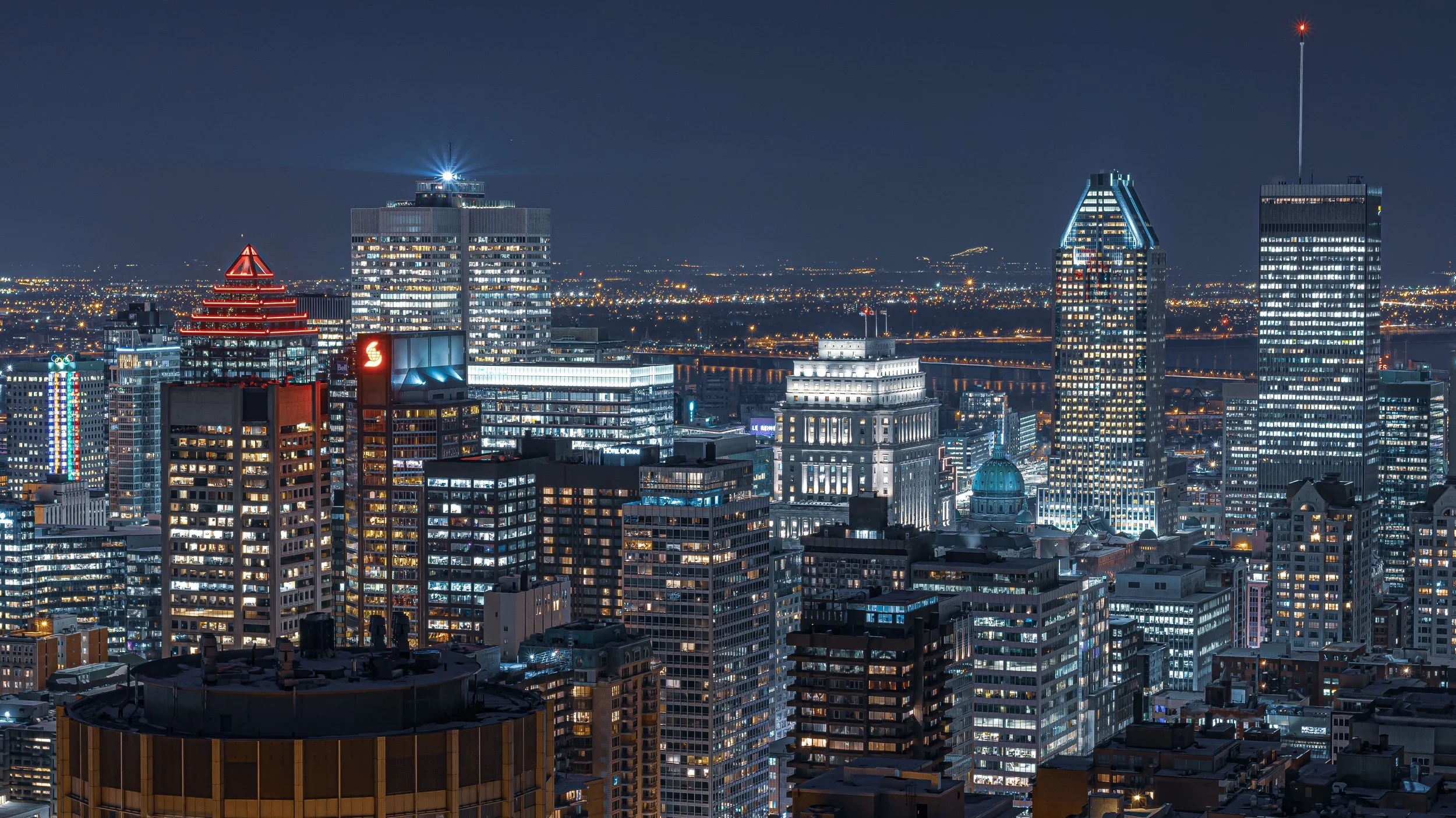 A breathtaking aerial view of Montreal's skyline at night showcasing modern architecture and vibrant city lights.