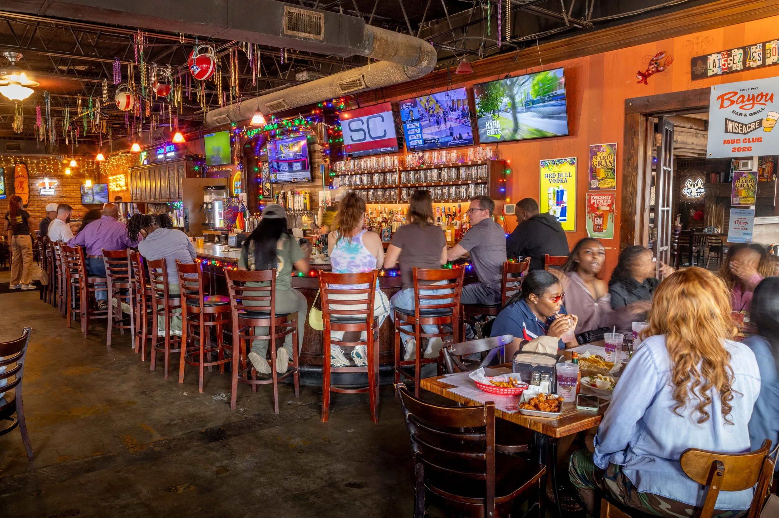 Interior shot of Bayou Bar with customers sitting at the bar and at tables.