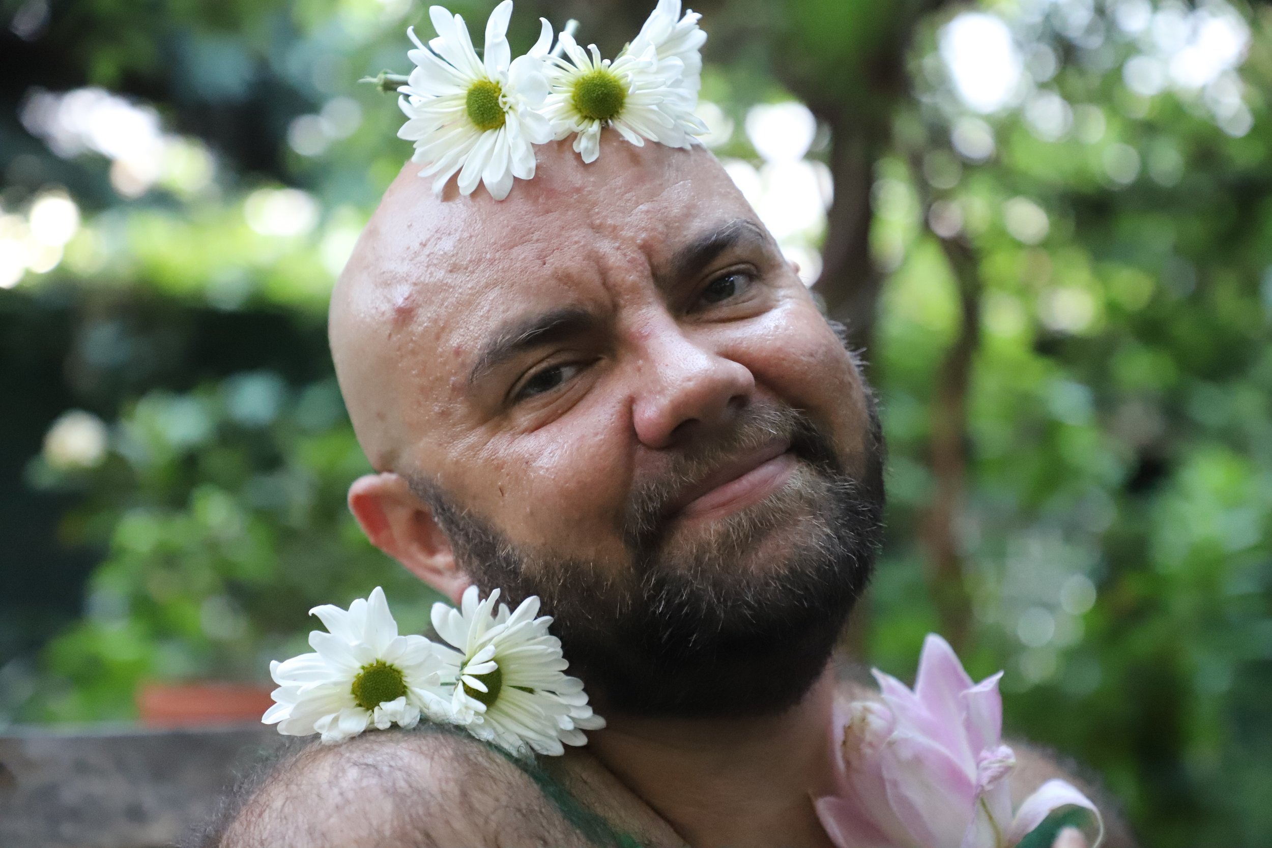 white smiling person with a bear and white flowers on their head