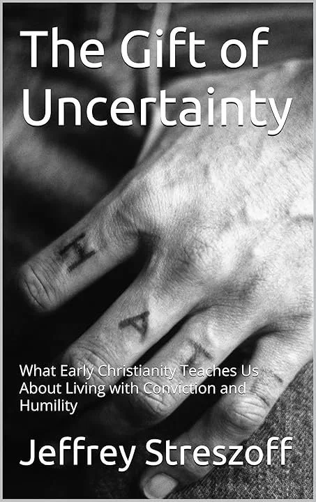 Book cover titled 'The Gift of Uncertainty' by Jeffrey Streszoff, showing a close-up black and white photo of a hand with the word 'FAITH' tattooed on the fingers, emphasizing themes of living with conviction and humility.